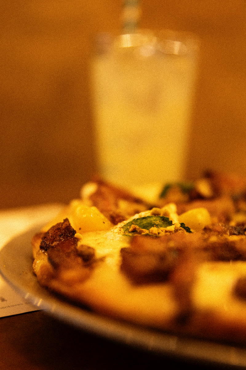 Pizza servie sur un plat métallique et verre de limonade