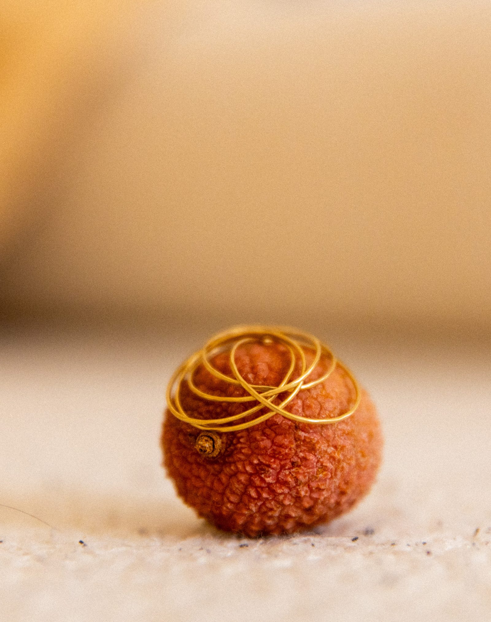 Litchi ceint de fils d'or, posé sur un tissu clair
