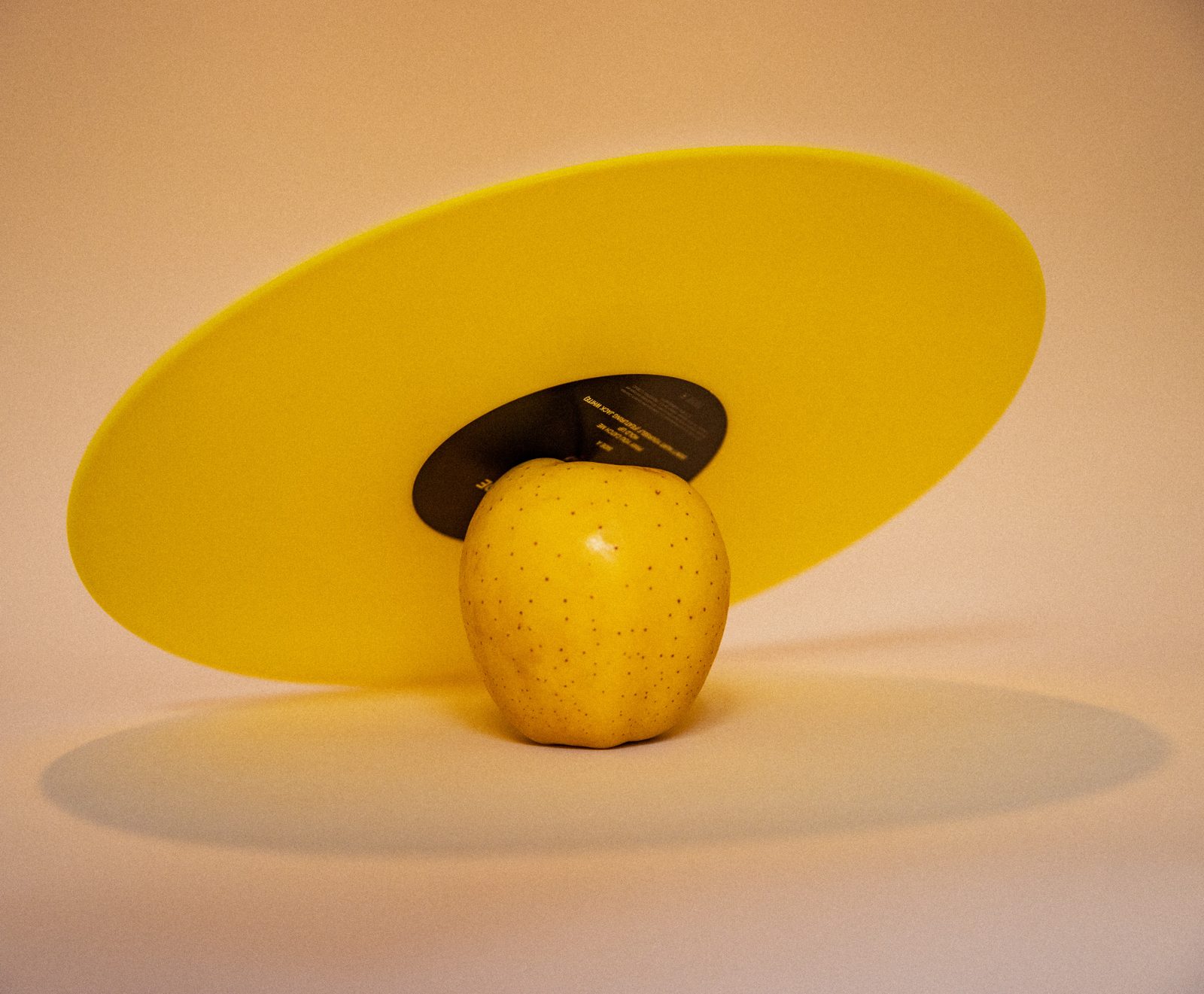 Pomme jaune devant un disque jaune et un vinyle noir, ombre douce